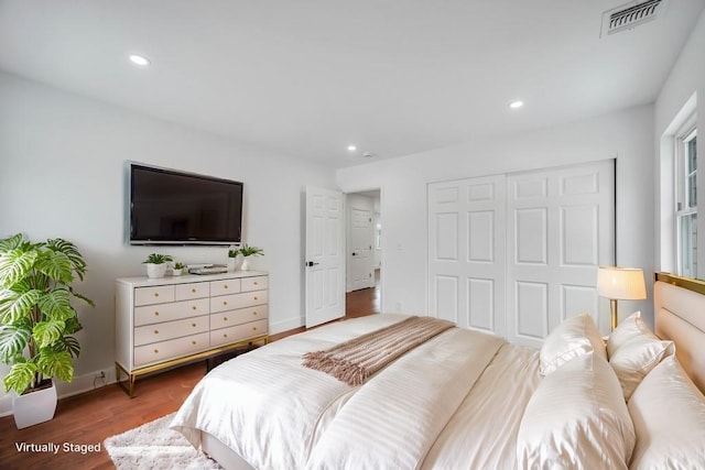 bedroom with dark hardwood / wood-style floors and a closet