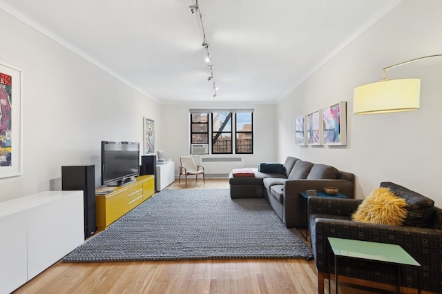 living room featuring ornamental molding, radiator heating unit, wood finished floors, and track lighting