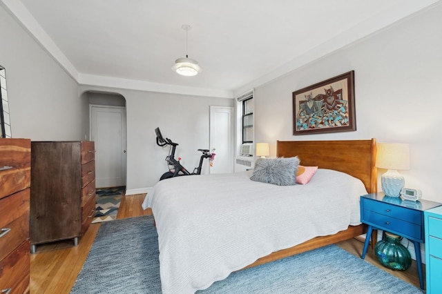 bedroom featuring light wood finished floors and baseboards