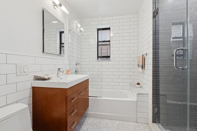 bathroom featuring toilet, shower / bath combination with glass door, tile patterned floors, vanity, and tile walls