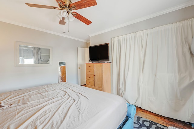 bedroom featuring ceiling fan, ornamental molding, and wood finished floors