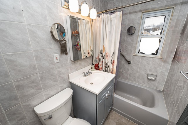 full bath with toilet, shower / tub combo, tile walls, and vanity