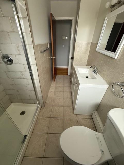 bathroom featuring tile walls, an enclosed shower, toilet, and tile patterned floors