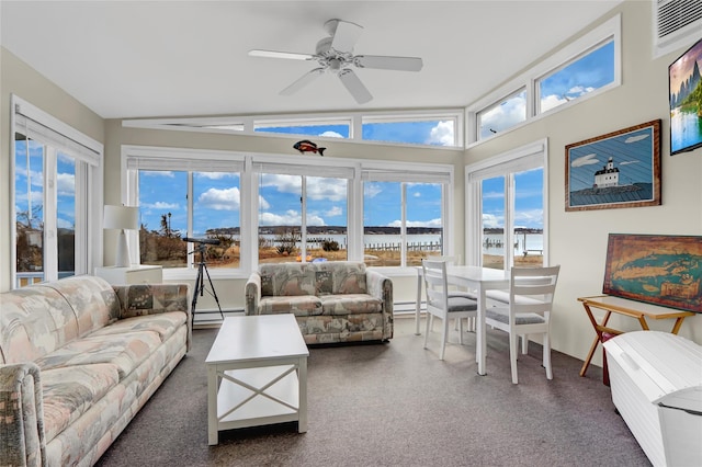 sunroom with baseboard heating, a water view, a wealth of natural light, and vaulted ceiling