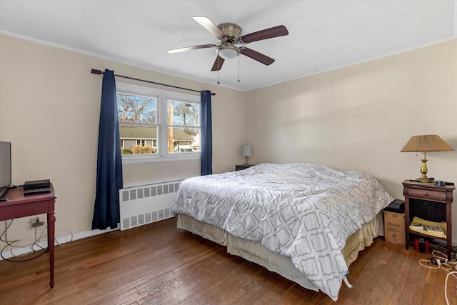 bedroom featuring ceiling fan, ornamental molding, wood-type flooring, and radiator