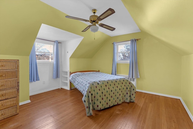 bedroom with multiple windows, hardwood / wood-style flooring, and baseboards