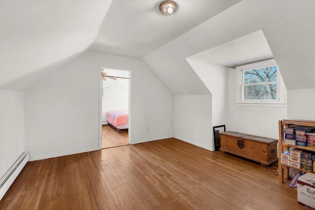 bonus room featuring baseboard heating, a baseboard heating unit, vaulted ceiling, and hardwood / wood-style floors