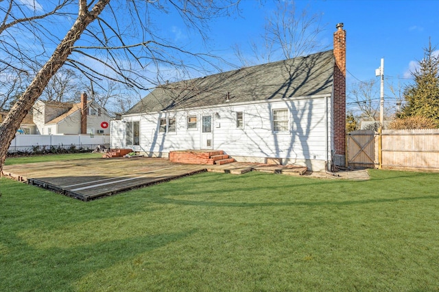 back of property featuring a yard, fence, a chimney, and a deck