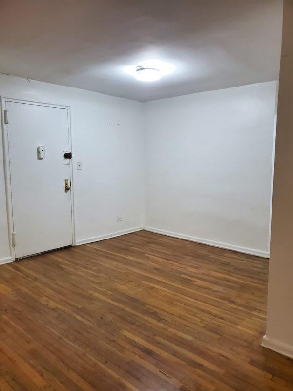 unfurnished room with dark wood-type flooring and baseboards