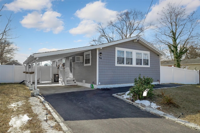 view of front of home featuring a wall unit AC and a carport