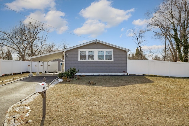 back of property with a lawn and a carport