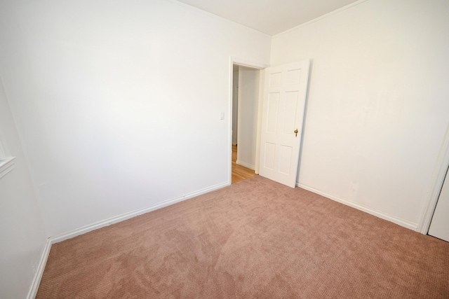 empty room with baseboards and light colored carpet