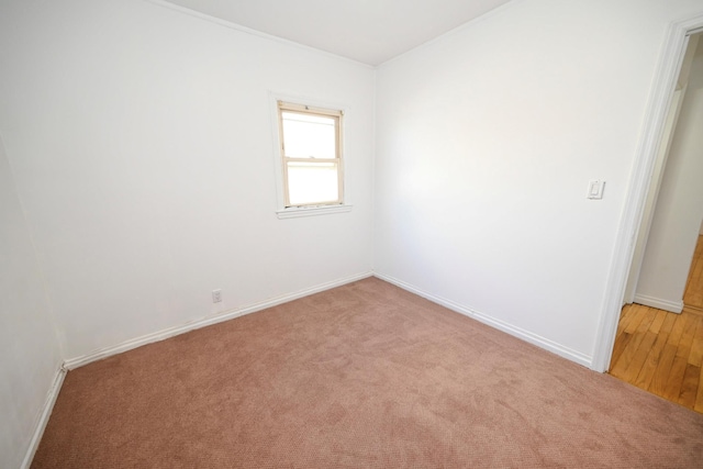 empty room featuring light carpet and baseboards