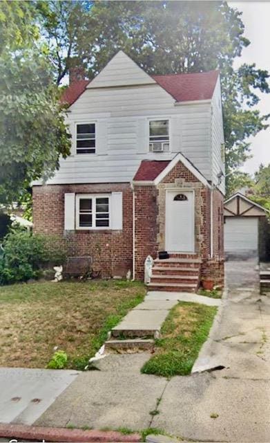 view of front of property featuring a garage and an outdoor structure