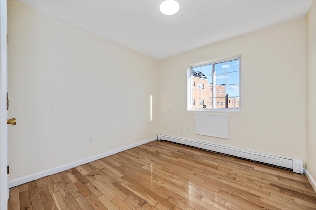 spare room featuring light hardwood / wood-style flooring and a baseboard radiator