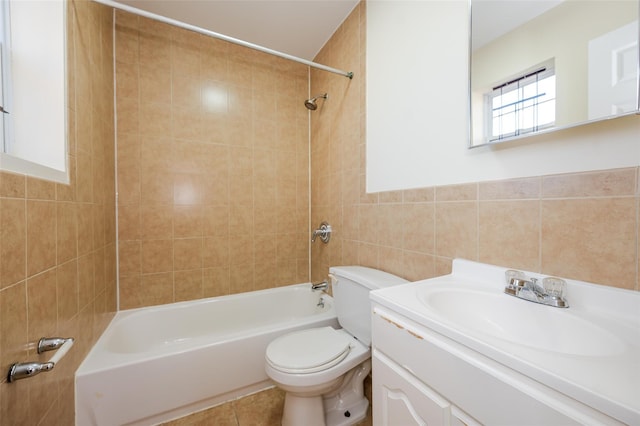 full bathroom with vanity, tile walls, toilet, and tiled shower / bath