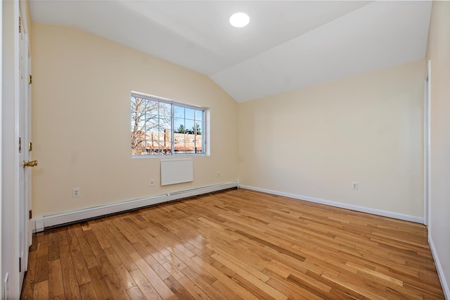 unfurnished room with vaulted ceiling, light hardwood / wood-style floors, and baseboard heating