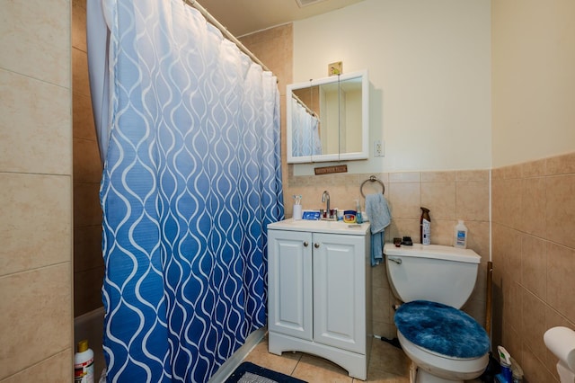 bathroom featuring vanity, tile patterned flooring, tile walls, and toilet