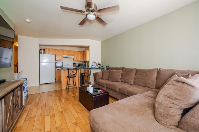 living room with ceiling fan and light wood-type flooring