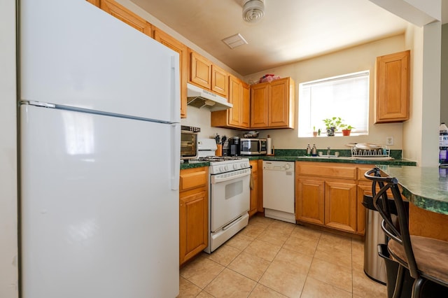 kitchen with white appliances, light tile patterned floors, and sink