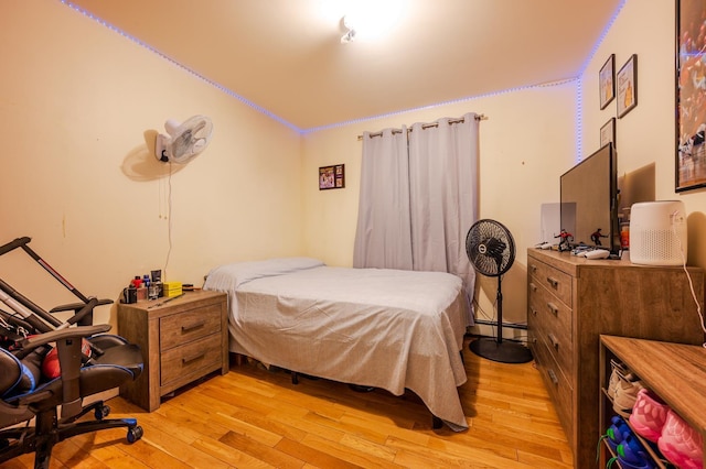 bedroom featuring light hardwood / wood-style floors and baseboard heating