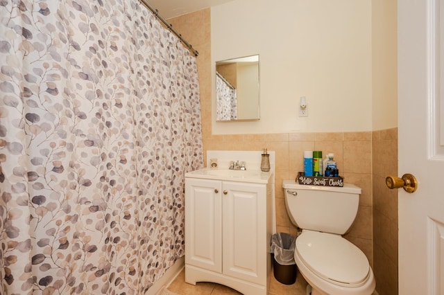 bathroom featuring toilet, tile patterned floors, tile walls, and vanity