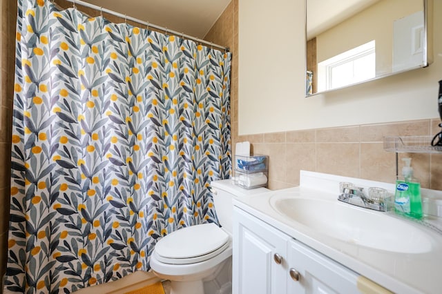 bathroom with tile walls, vanity, and toilet