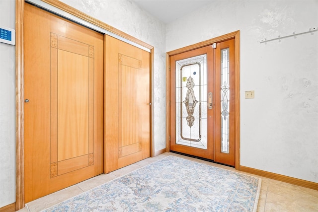 entrance foyer featuring light tile patterned floors and baseboards