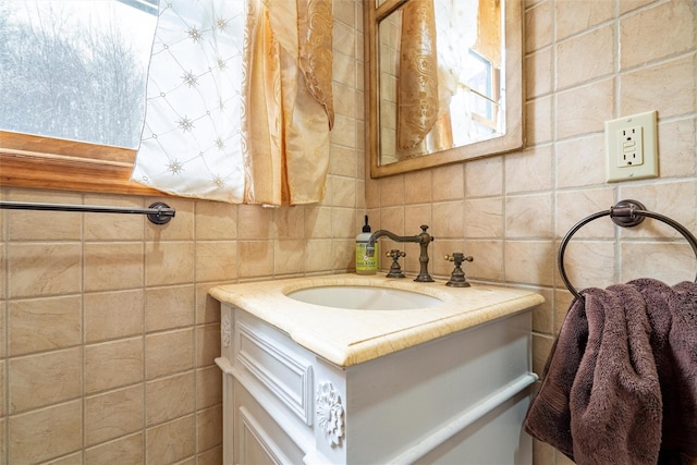 bathroom with vanity and tile walls