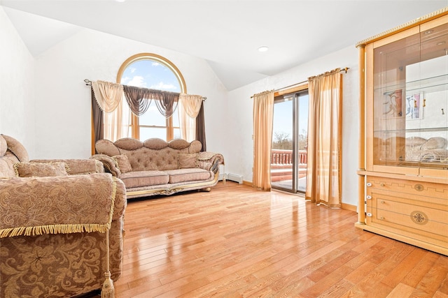 sitting room with a wealth of natural light, a baseboard radiator, vaulted ceiling, and wood finished floors