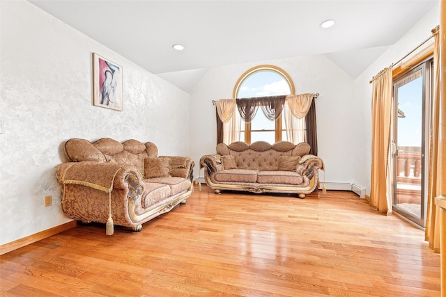 living room featuring lofted ceiling, baseboard heating, and wood finished floors