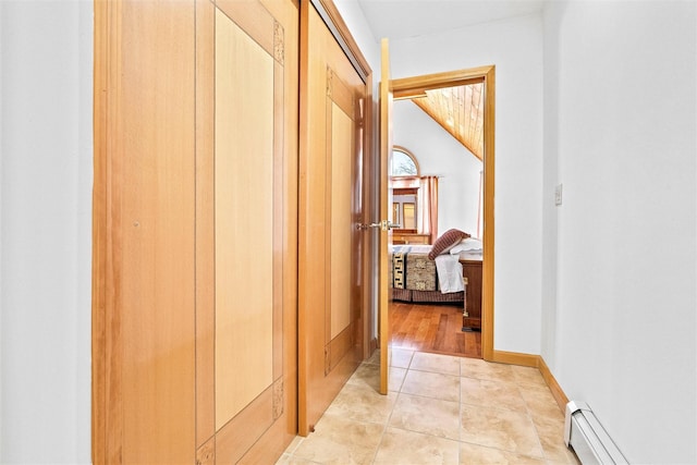 hall with light tile patterned floors, baseboard heating, and baseboards