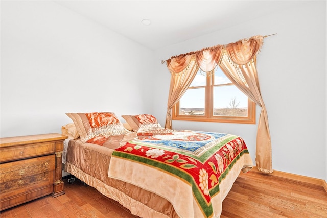 bedroom featuring baseboards and wood finished floors