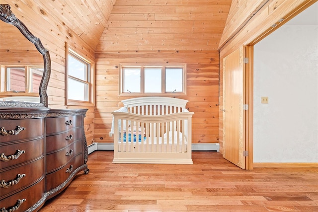 bedroom featuring wood walls, vaulted ceiling, light wood-style flooring, and baseboard heating