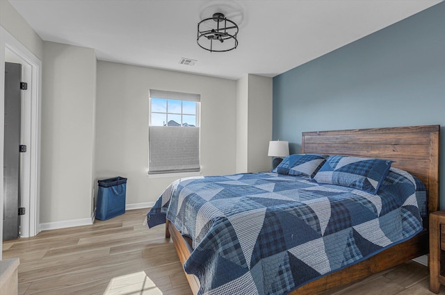 bedroom featuring light wood-style flooring, baseboards, and visible vents