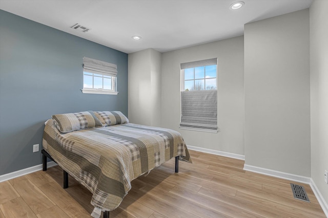 bedroom featuring light wood-style flooring, baseboards, and visible vents