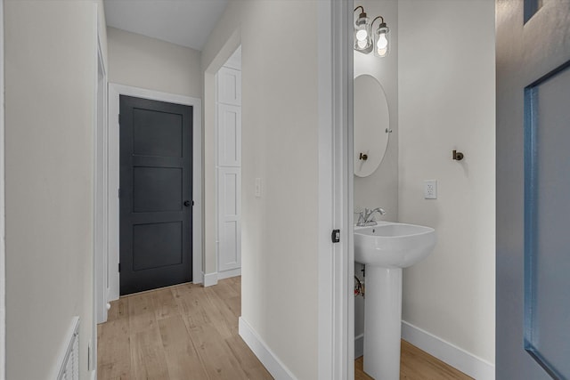 bathroom featuring a sink, baseboards, and wood finished floors