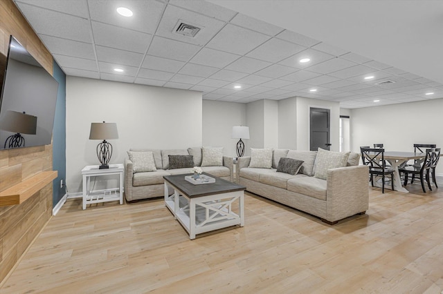 living area with baseboards, visible vents, recessed lighting, light wood-style floors, and a drop ceiling