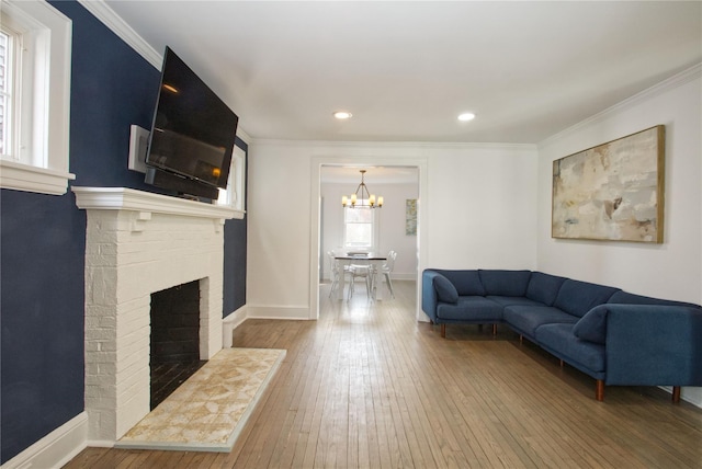 living area with hardwood / wood-style floors, a fireplace, and crown molding