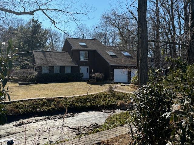 view of front of property with a garage and a front lawn