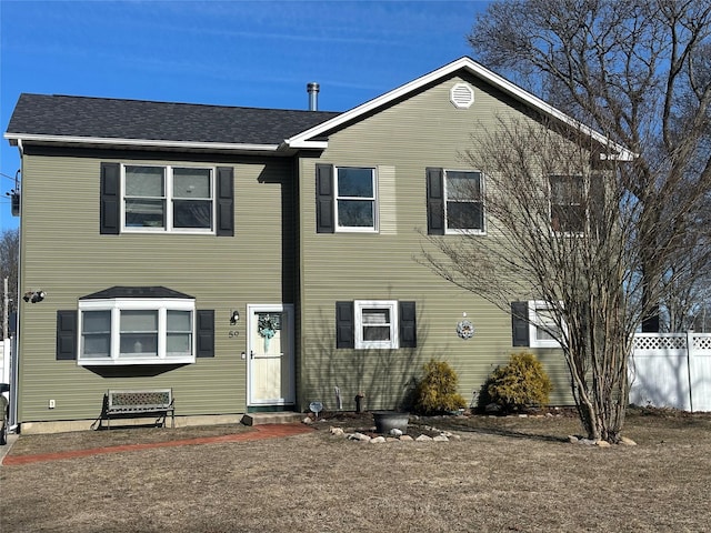 view of front of home featuring a patio area, a shingled roof, and fence