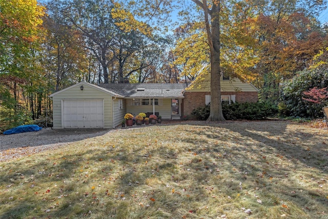 single story home featuring an attached garage, a front lawn, and brick siding