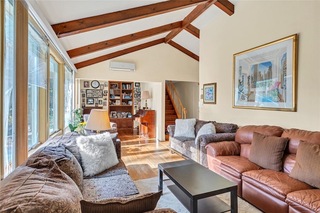 living room with high vaulted ceiling, a wall unit AC, stairway, beam ceiling, and light wood finished floors