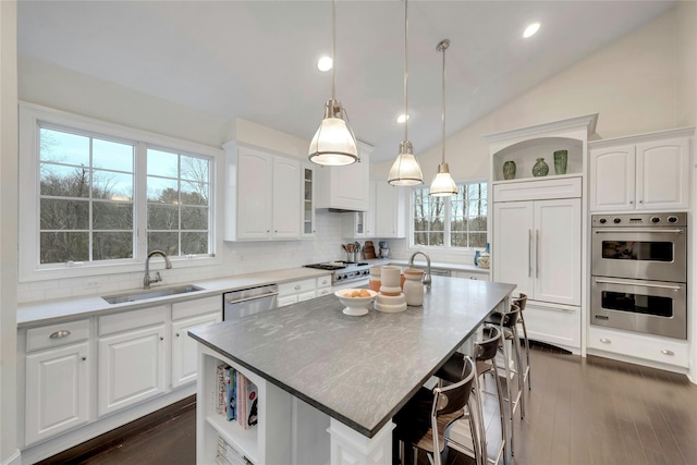 kitchen featuring white cabinetry, open shelves, appliances with stainless steel finishes, and a sink