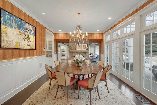 dining space with visible vents, wood finished floors, crown molding, and french doors