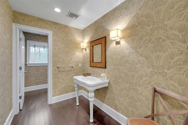 bathroom with visible vents, wallpapered walls, baseboards, and wood finished floors