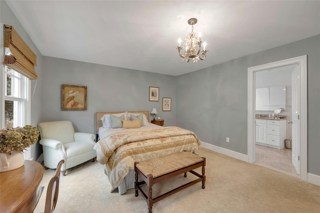 bedroom featuring a chandelier, light carpet, ensuite bathroom, and baseboards