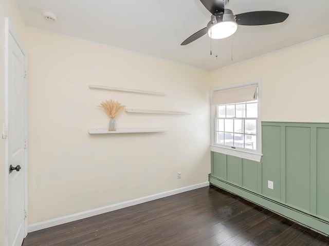 spare room with a baseboard heating unit, ornamental molding, dark hardwood / wood-style floors, and ceiling fan