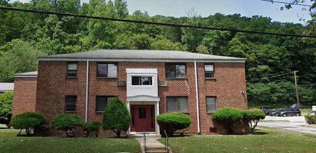 view of front of property featuring brick siding and a front yard