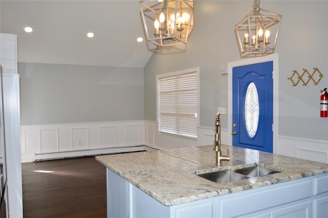 kitchen with white cabinetry, hanging light fixtures, light stone countertops, sink, and a baseboard radiator